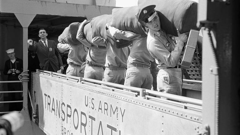 American musician (and actor) Elvis Presley (1935 - 1977) (right) looks back as he boards the USS Randall via the gangplank and prepares to ship out, New York, New York, September 22, 1958.