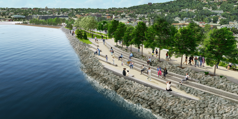 Rendering of people walking and relaxing on a tree-lined new stapleton waterfront esplanade beside a rocky shore, with a view of New York City and hills in the background.