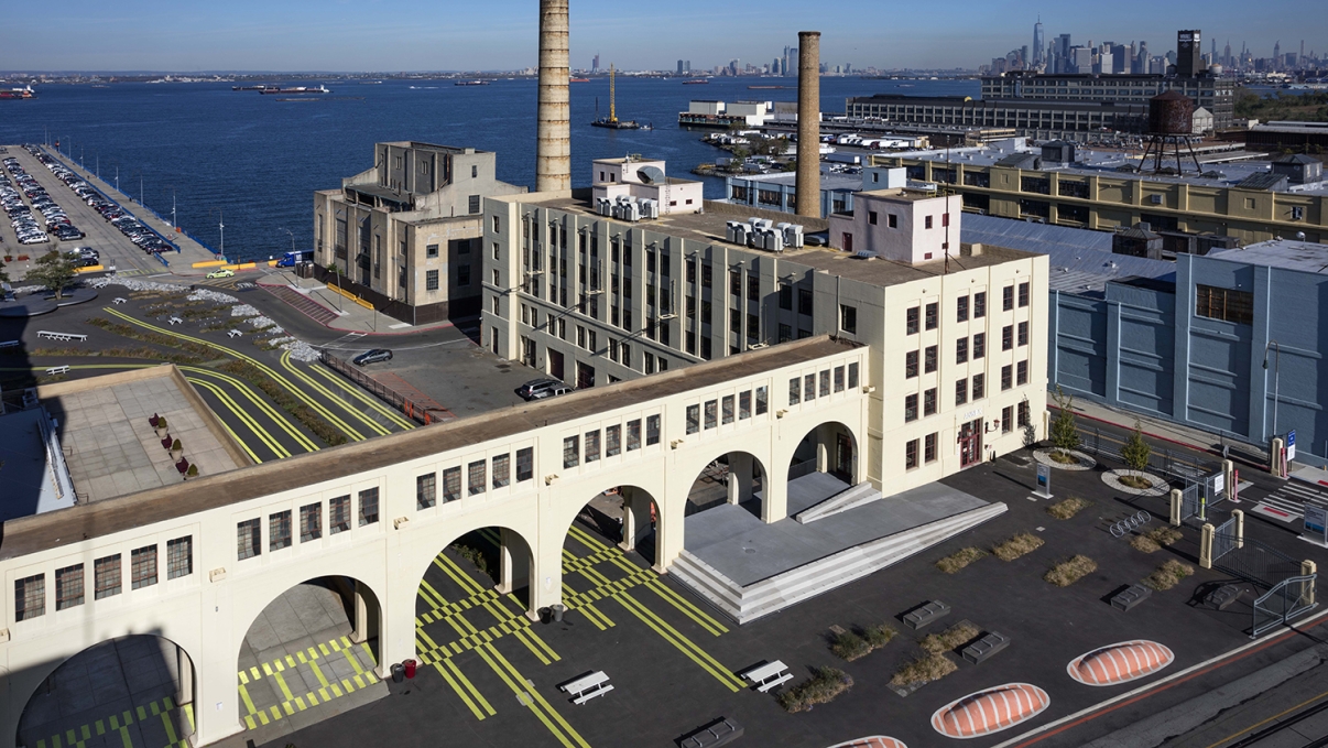 Exterior of Brooklyn Army Terminal Annex Building, waterfront, and Manhattan skyline.