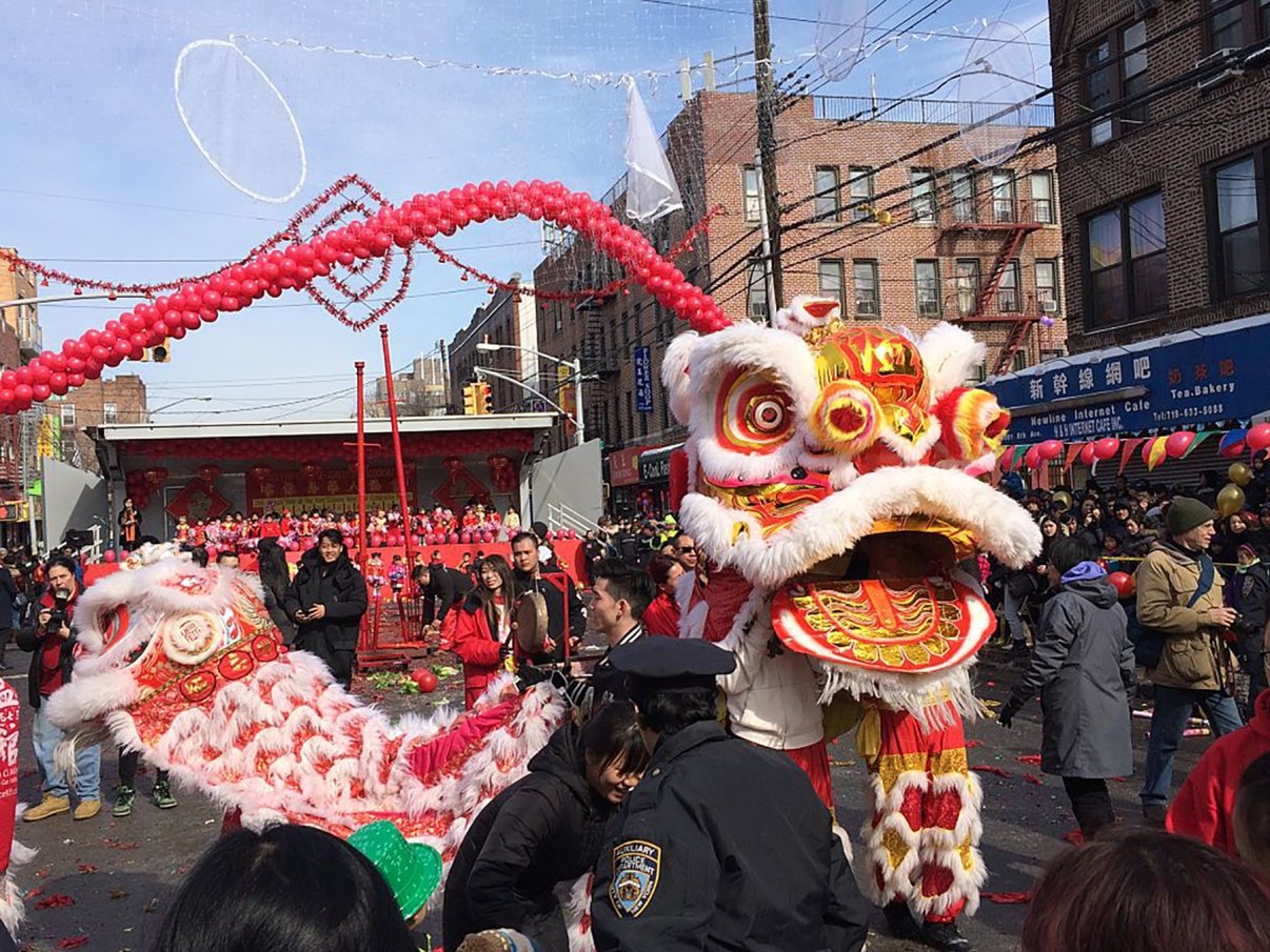 Lion &amp; Dragon Dance street performance in front of the main stage at the Chinese New Years Festival &amp; Parade during the celebration in the Chinatown section of Sunset Park, Brooklyn, NYC.